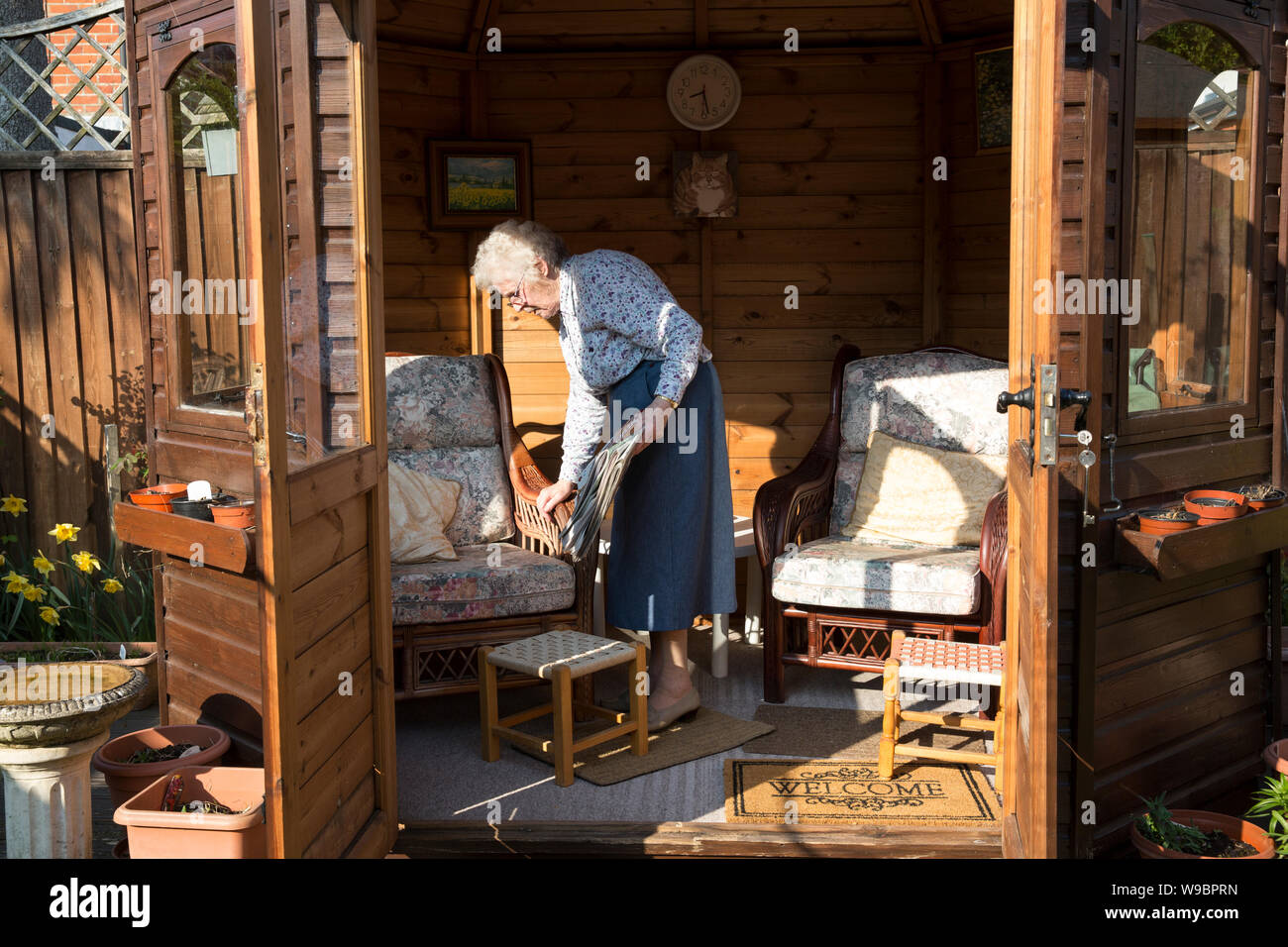 Elderly lady outside in her garden summerhouse at a residential home, southwest England, United Kingdom Stock Photo