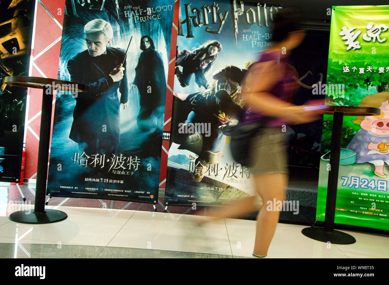 A Chinese woman walks past a poster of the film Harry Potter and the Half-Blood Prince at a cinema in Beijing, China, 18 July 2009.   Though Chinese f Stock Photo