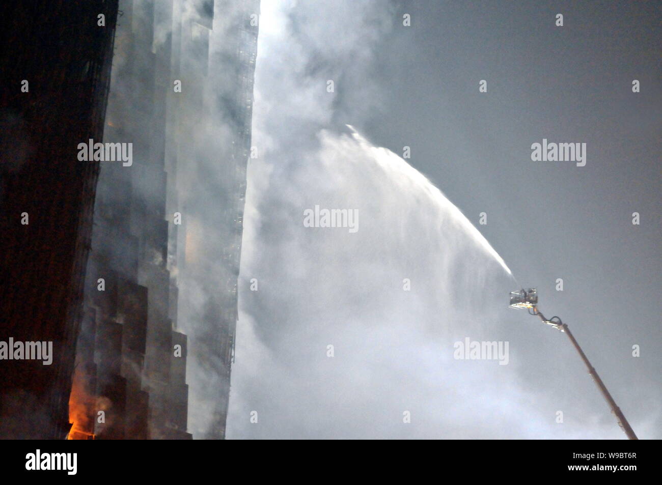 Fire fighters try to extinguish the fire in the Mandarin Oriental Hotel building near the new CCTV Tower during the Lantern Festival in Beijing, China Stock Photo