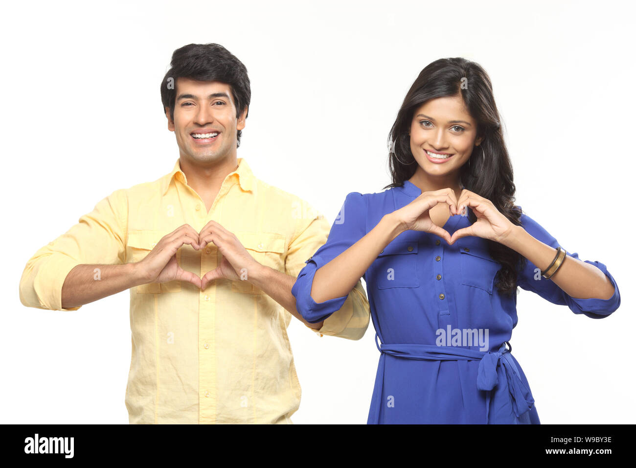 Young couple making heart shape with hands and smiling Stock Photo - Alamy