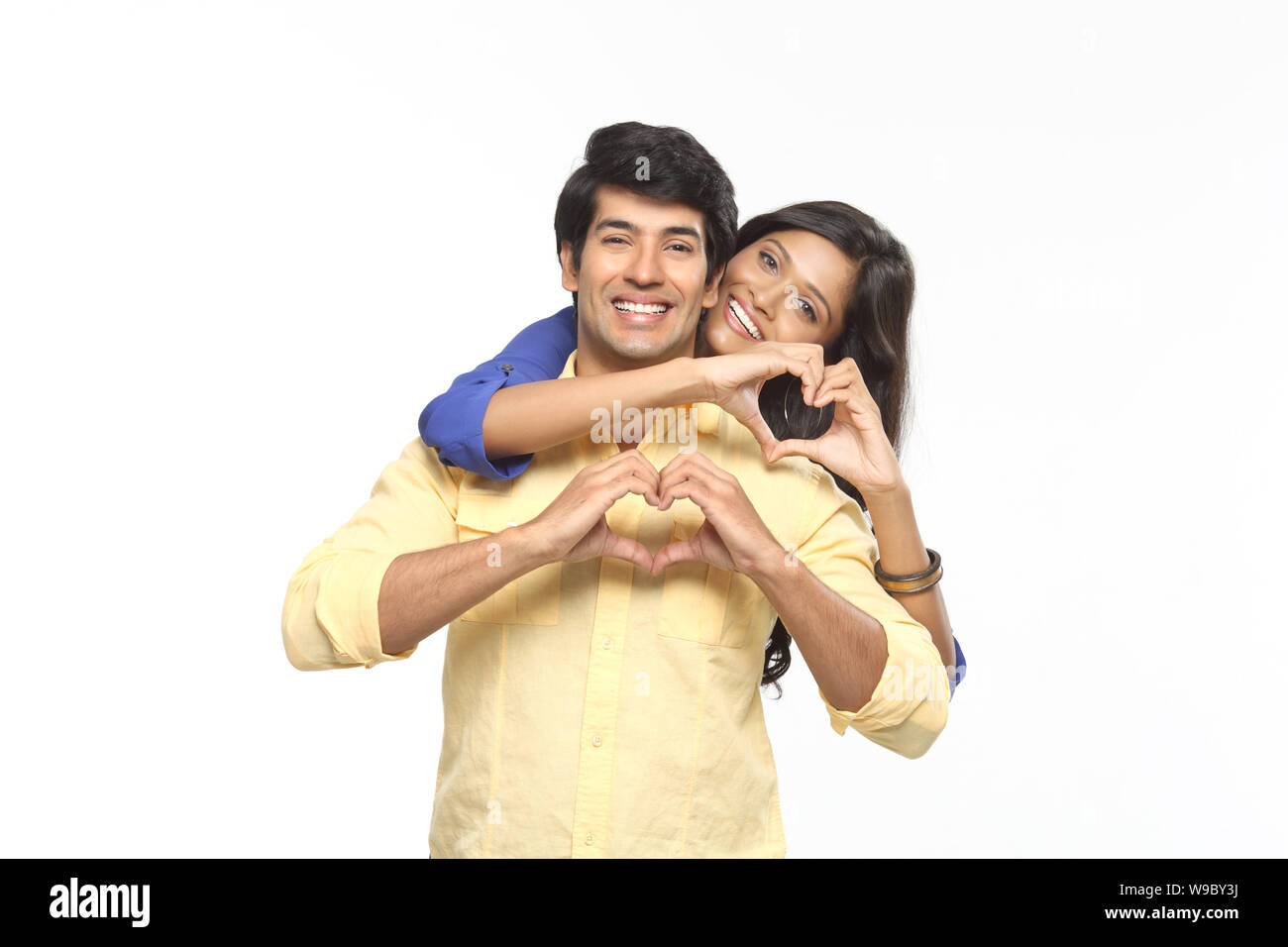 Young couple making heart shape with hands and smiling Stock Photo - Alamy