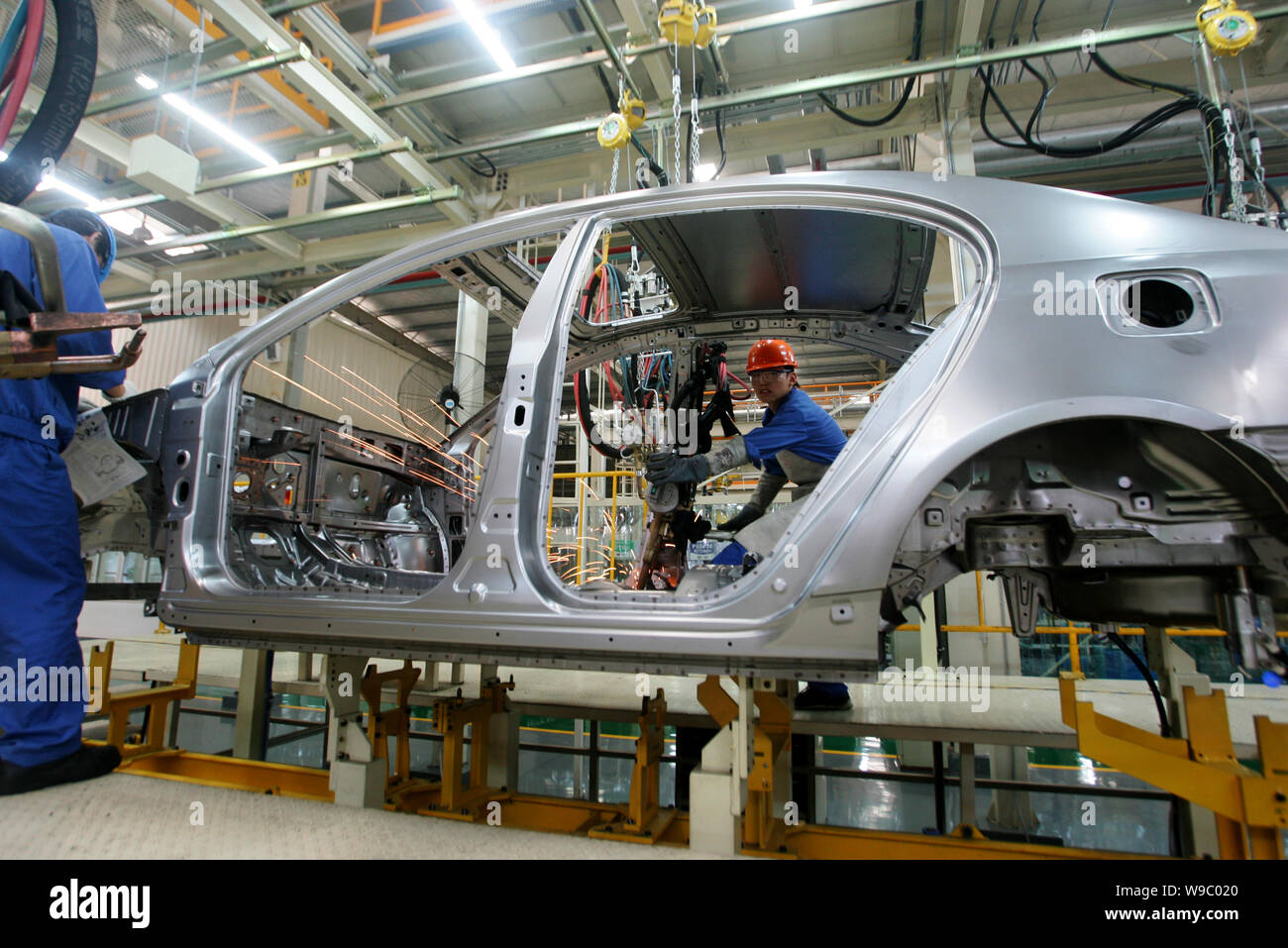 FILE Chinese factory workers assemble a car on the production line