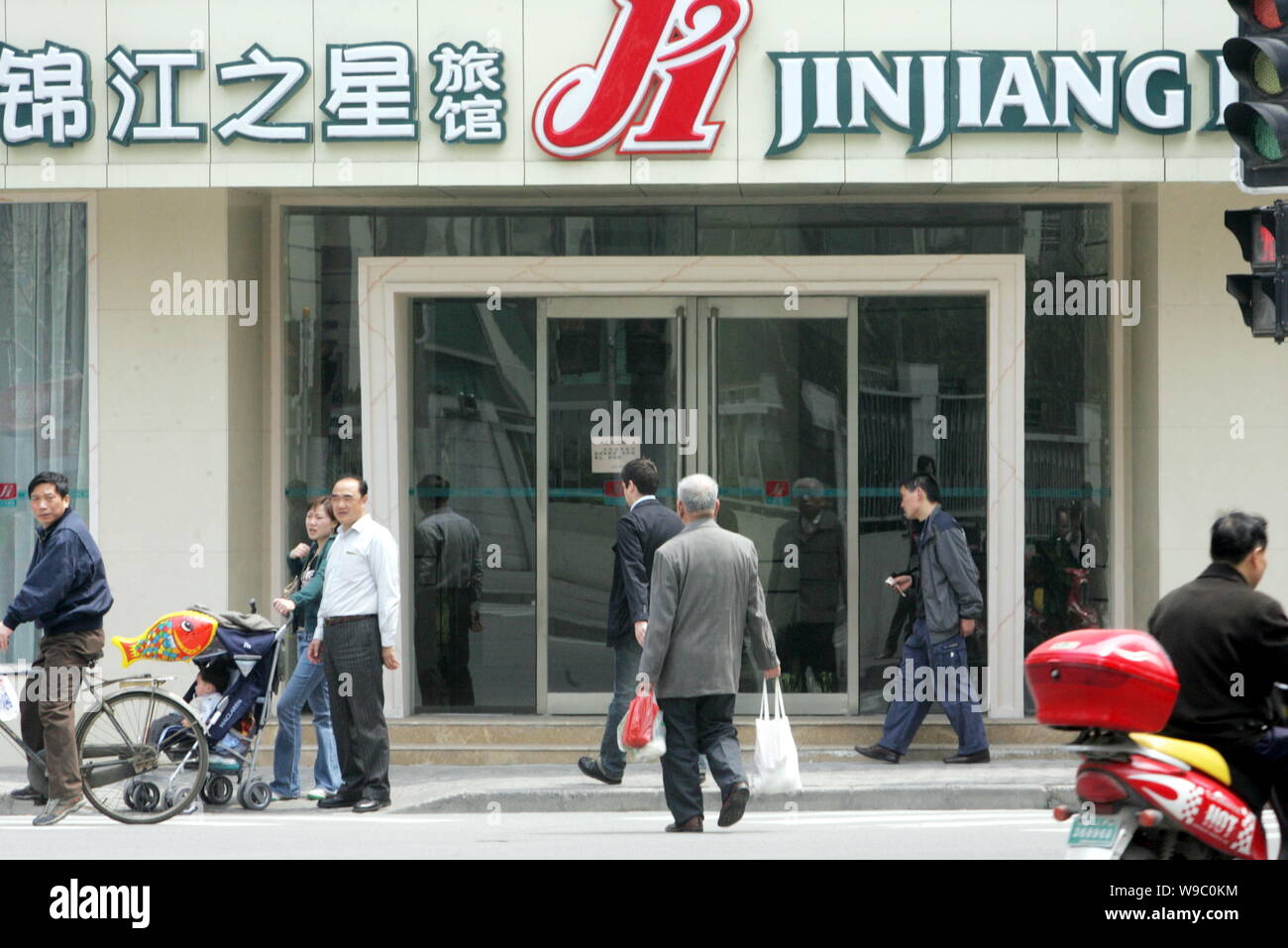 --FILE--Local Chinese citizens pass by a branch of Jinjiang Inn in Shanghai, China, 7 April 2008.   Jinjiang Inn Budget Hotels, a subsidiary of Shangh Stock Photo