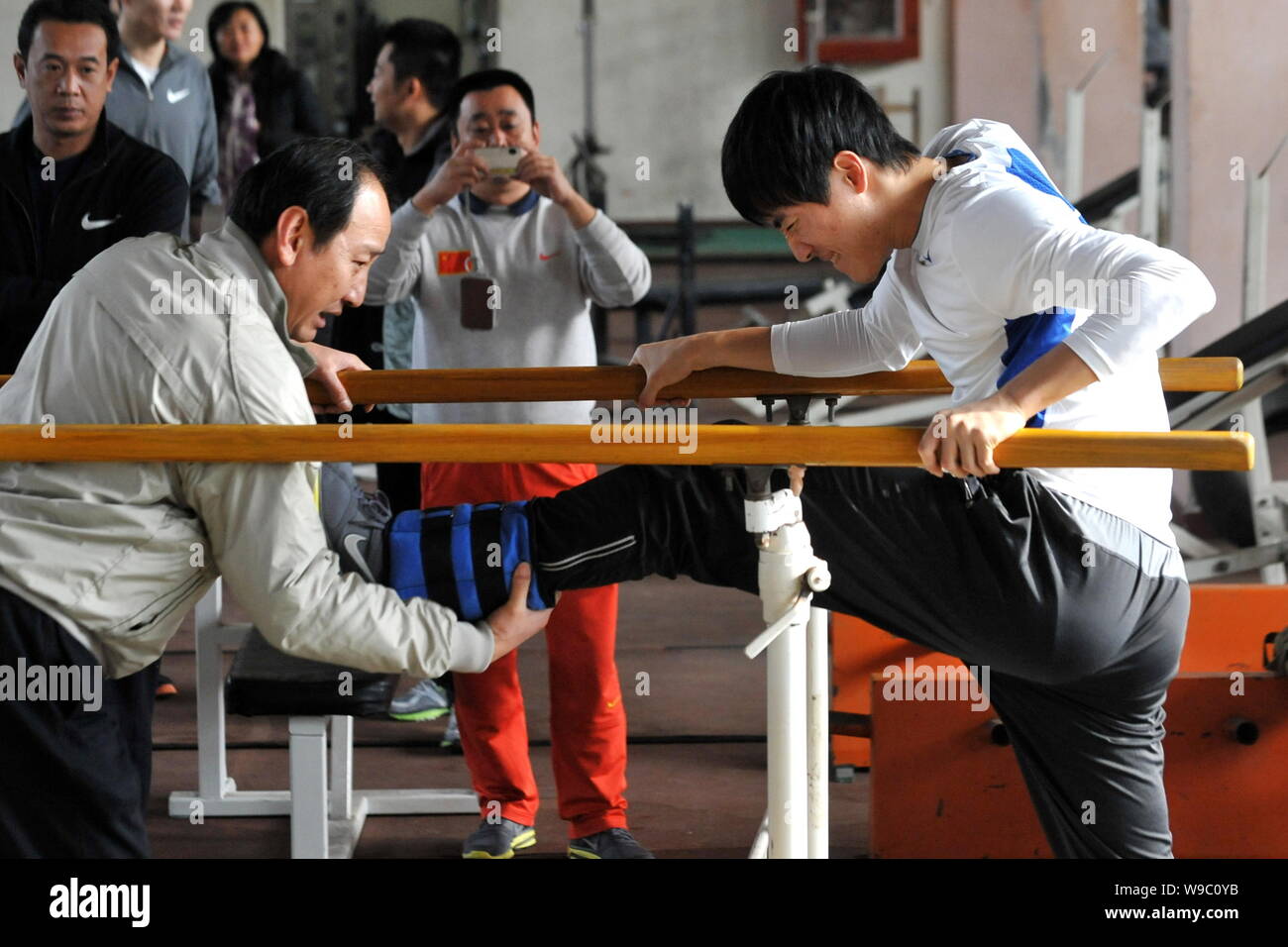 Sun Haiping, left, the coach of Chinese star hurdler Liu Xiang, helps Liu exercise during a training session at the Xinzhuang training base in Shangha Stock Photo