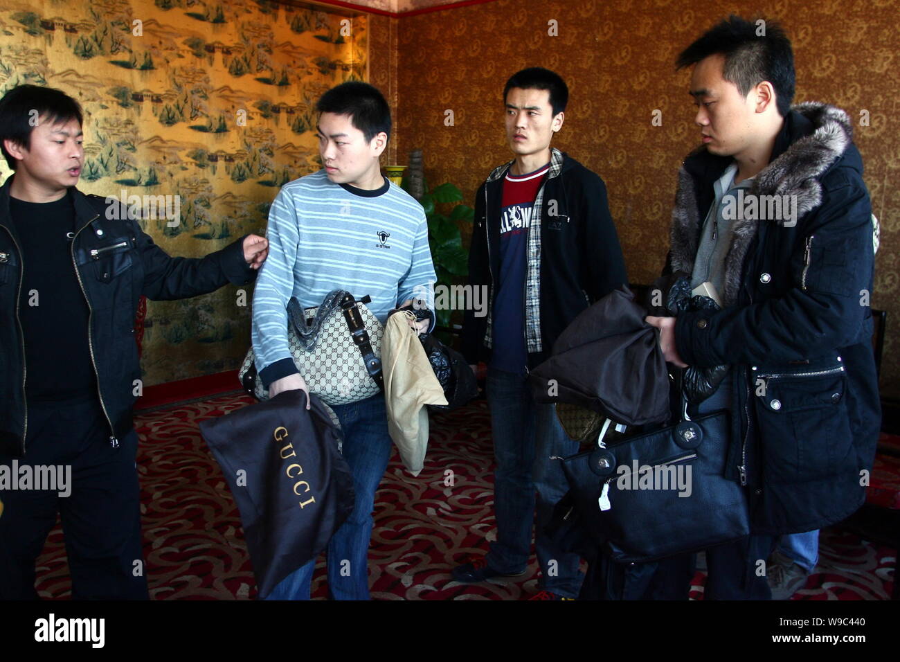 Chinese market administrators seize two fake goods sellers at the Silk Street Market in Beijing, China, Sunday, 15 February 2009.   Eight more shops i Stock Photo