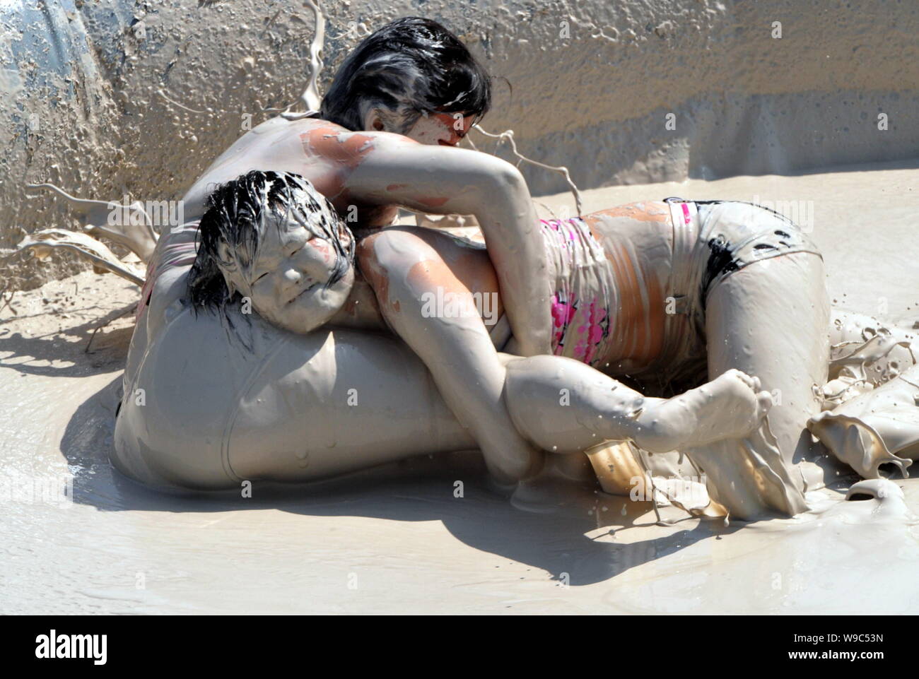 Two Chinese women wrestle in a mud pool during an interntional womens mud wrestling contest along the East Lake in Wuhan city, central Chinas Hubei pr Stock Photo