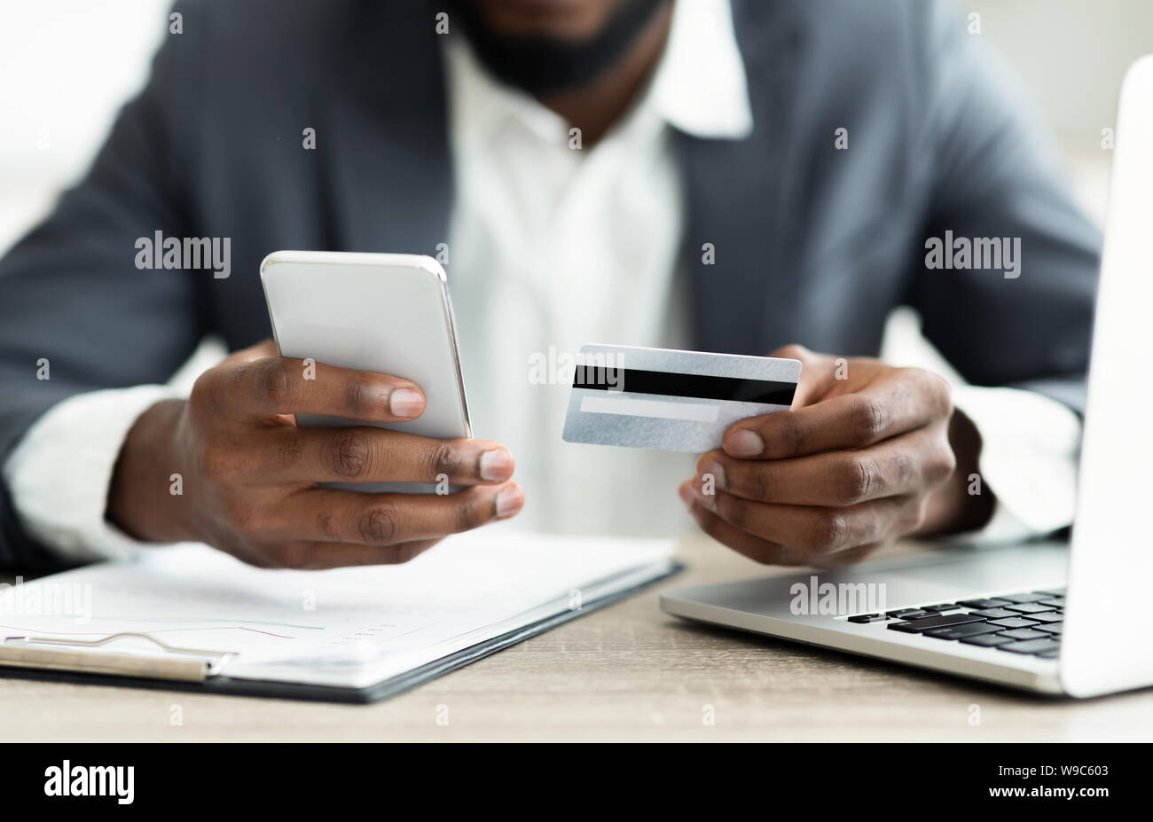 Serious businessman paying his bills online using application in smartphone Stock Photo