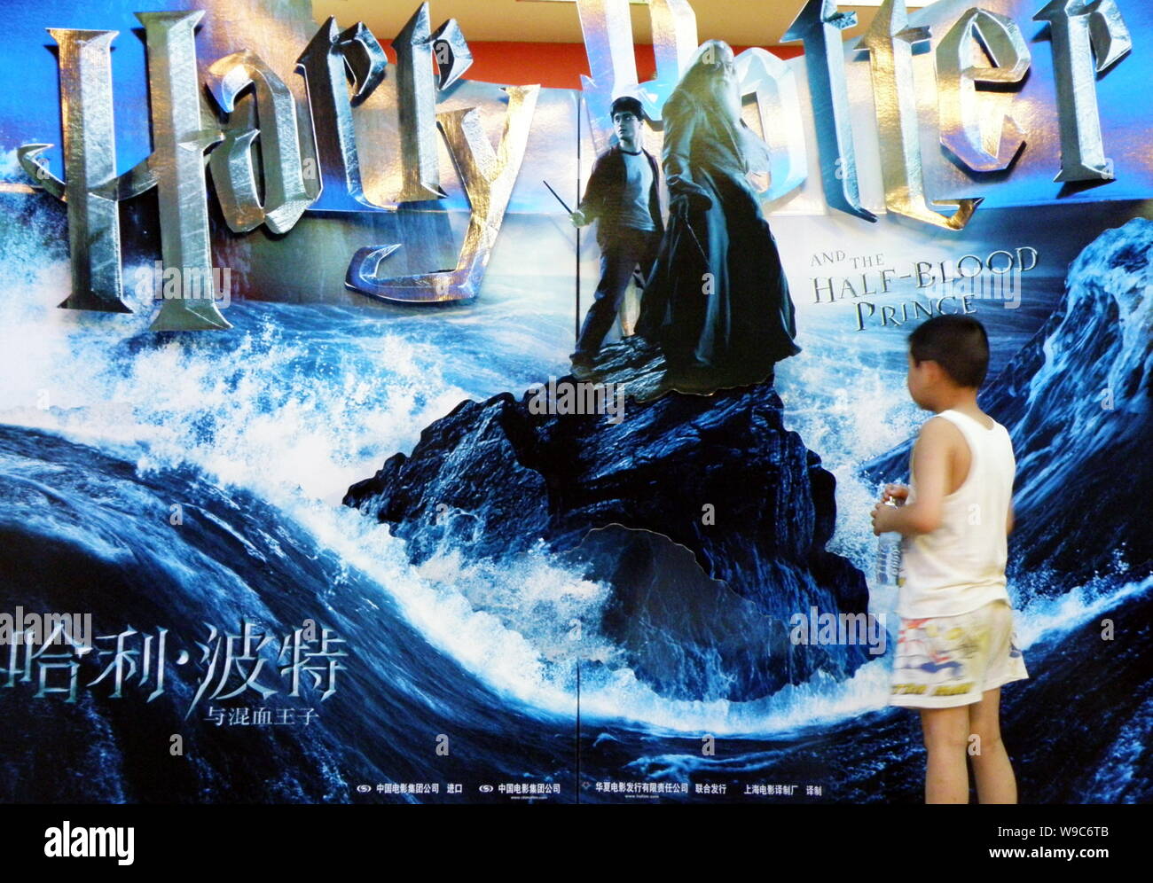 A Chinese child looks at a poster of the film Harry Potter and the Half-Blood Prince at a cinema in Yichang city, central Chinas Hubei province, 13 Ju Stock Photo