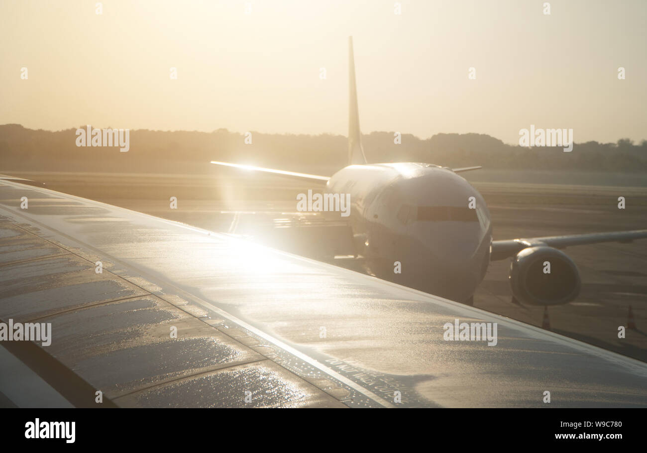 Part of airplane on the runway at sunset Stock Photo - Alamy