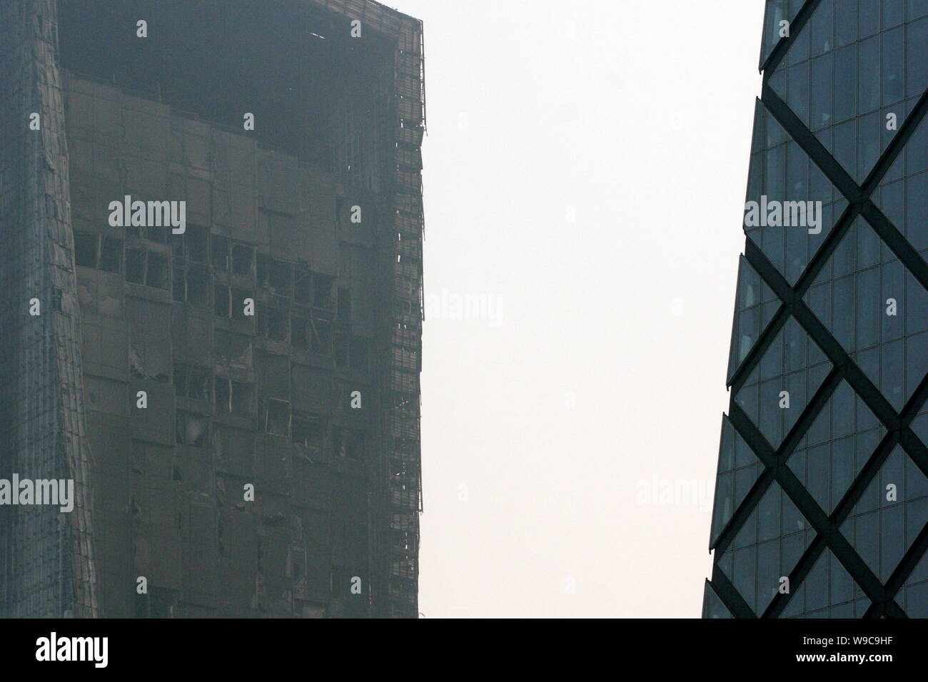 The damaged Mandarin Oriental Hotel building is seen near the new CCTV Tower in Beijing, China, Tuesday, 10 February 2009.   A hotel building under co Stock Photo