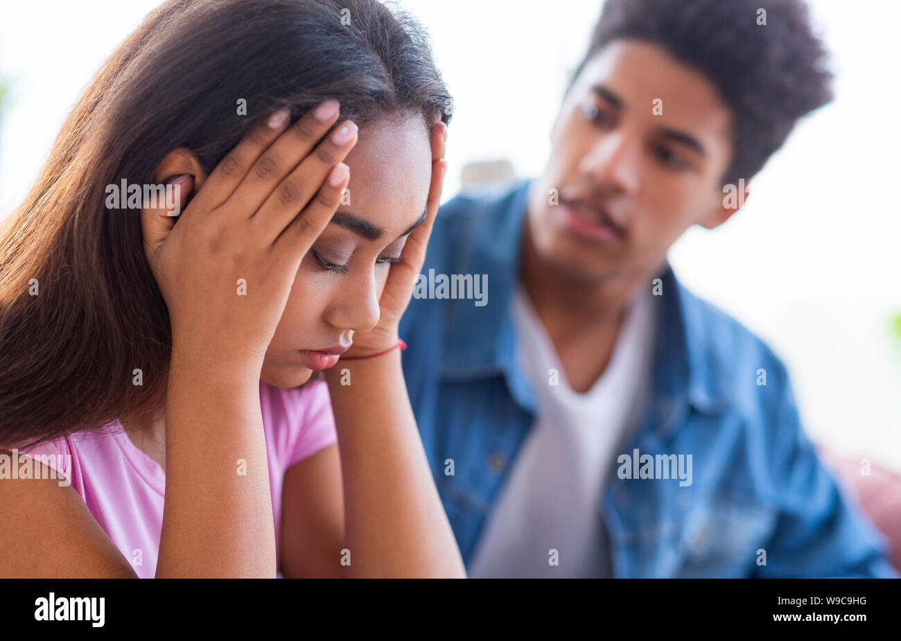 Black teen guy comforting his upset female friend Stock Photo