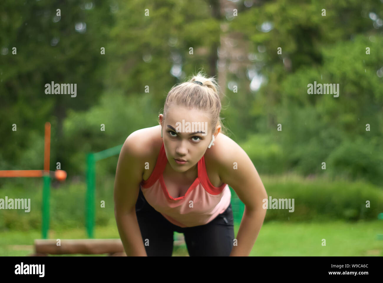 young woman is out of breath and makes a breather bent over while doing
