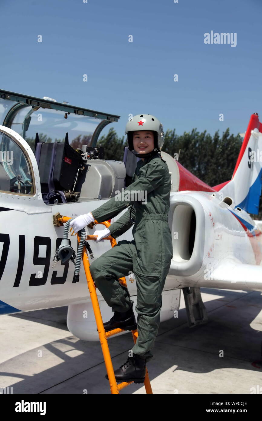 A young female fighter plane pilot of Chinese PLA Air Force boards a training plane after a new flight suits delivery ceremony at an airport in Tangsh Stock Photo