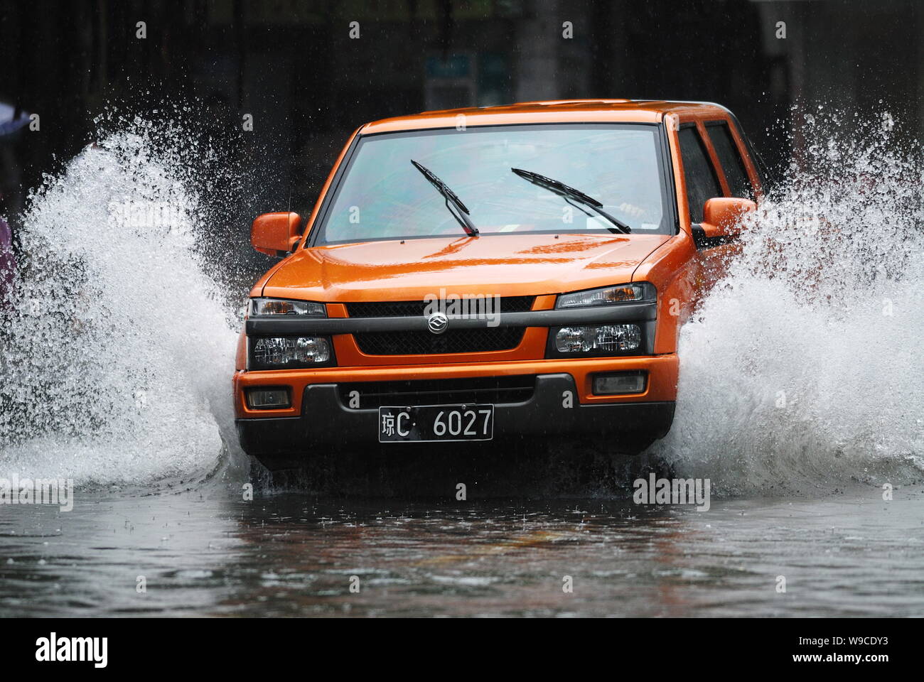 A car drives through a flooded street after heavy rain caused by Tropical Storm Parma in Haikou city, south Chinas Hainan province, Monday, 12 October Stock Photo