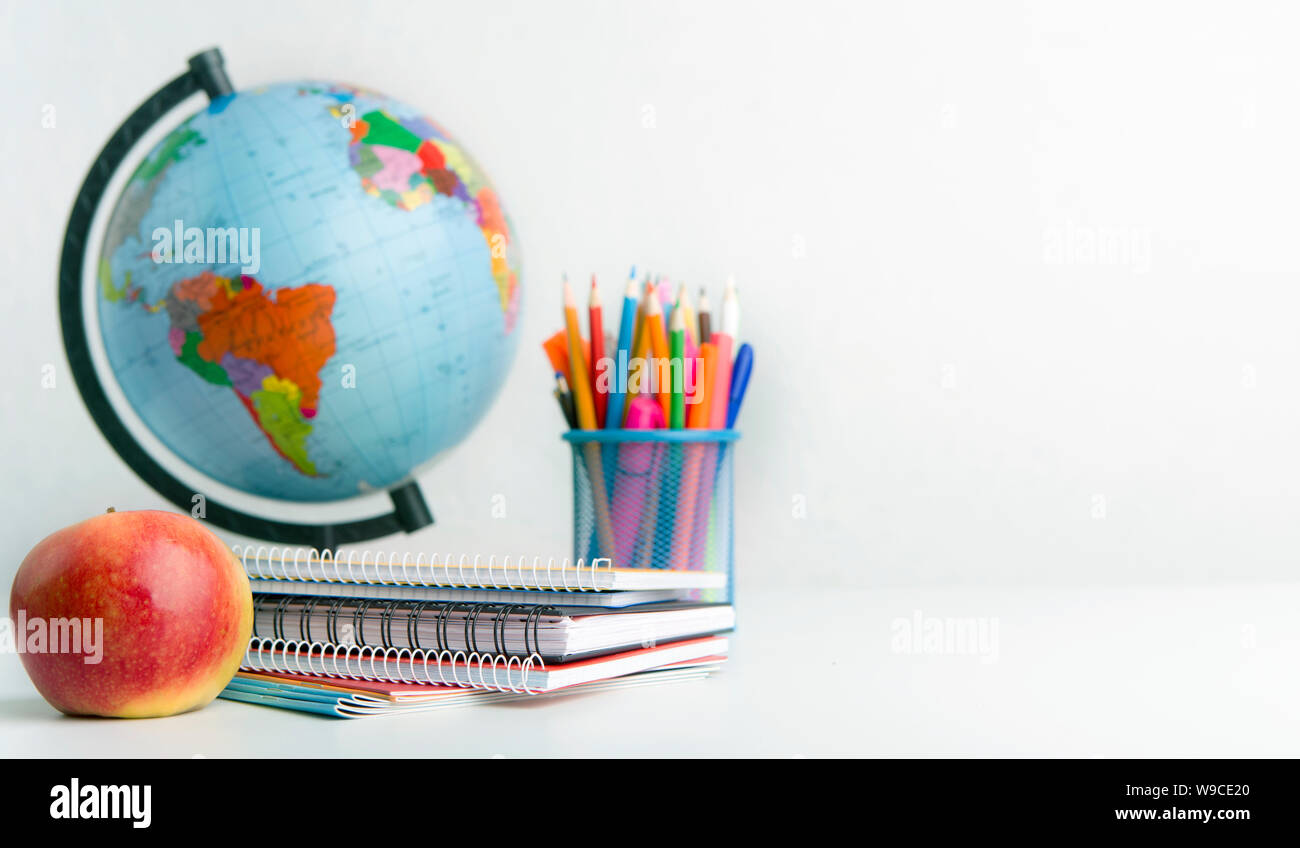World globe, apple and supplies on white background Stock Photo Alamy