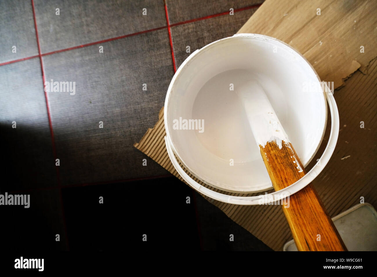 mixing white paint in a bucket on the floor Stock Photo Alamy