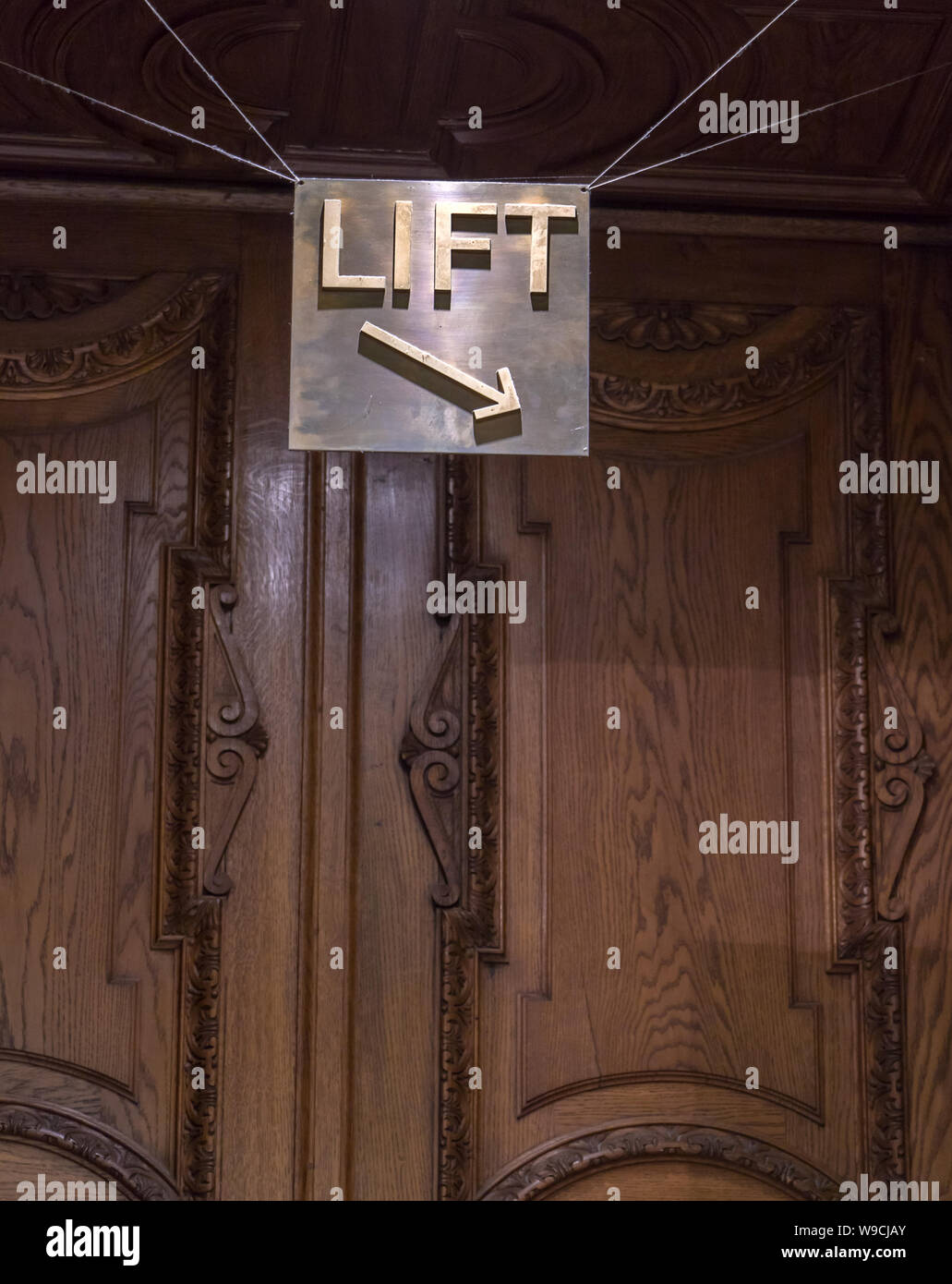 A sign with the inscription Lift hanging on the ceiling and shows the direction of the elevator. Stock Photo