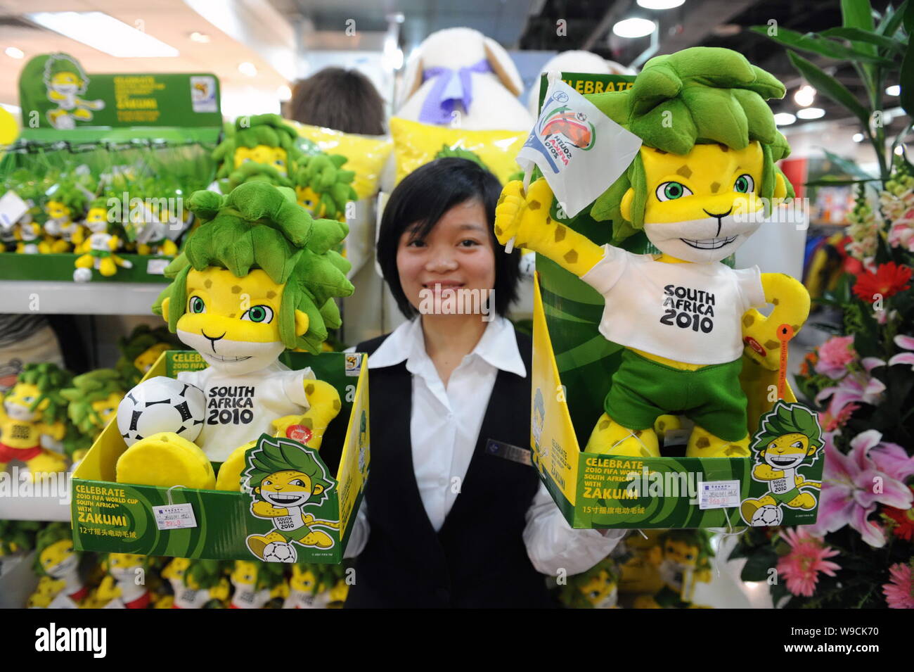 A saleswoman shows toys of Zakumi, the official mascot of 2010 FIFA World Cup South Africa , at a department store in Beijing, China, November 17, 200 Stock Photo