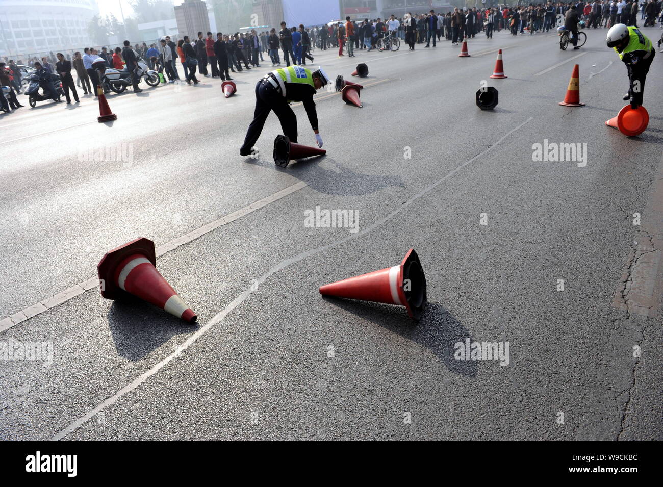 Chinese police officers put back traffic cones kicked down by angry