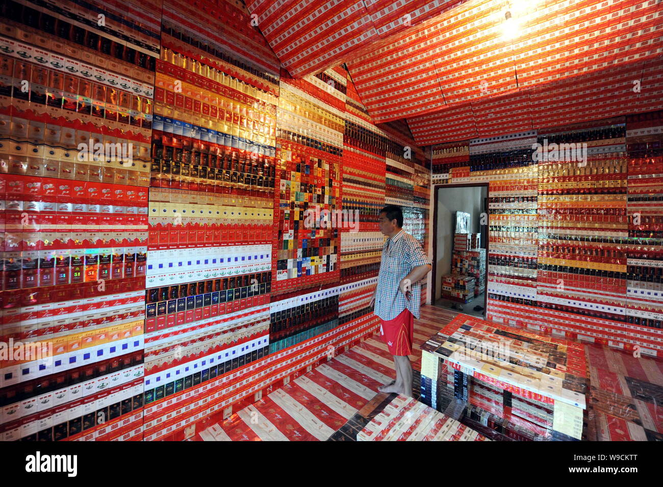Chinese collector Wang Guohua looks at his collections of cigarette boxes  in a room in Hangzhou city, east Chinas Zhejiang province, Tuesday, 25  Augus Stock Photo