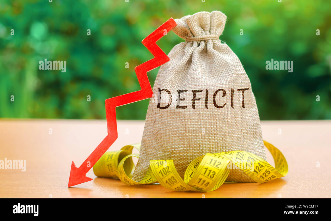 Money bag with the word Deficit and tape measure with down arrow ...