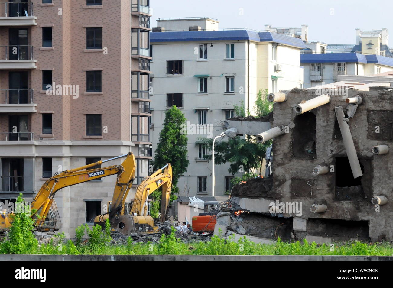 Excavators are seen dismantling the toppled apartment building at the ...