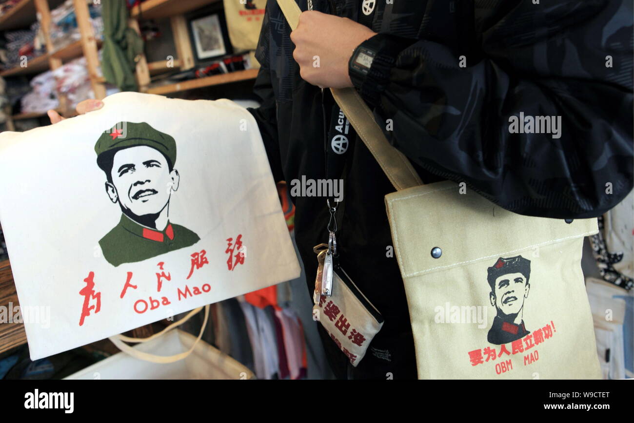 A Chinese man shows shopping bags printed with the portait of U.S. President Barrack Obama wearing the Chinese Red Army uniform in a shop in the Shich Stock Photo