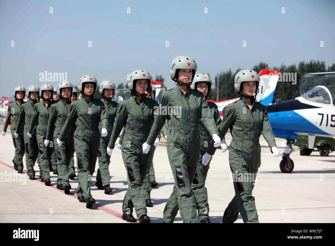 Young female fighter plane pilots of Chinese PLA Air Force walk past