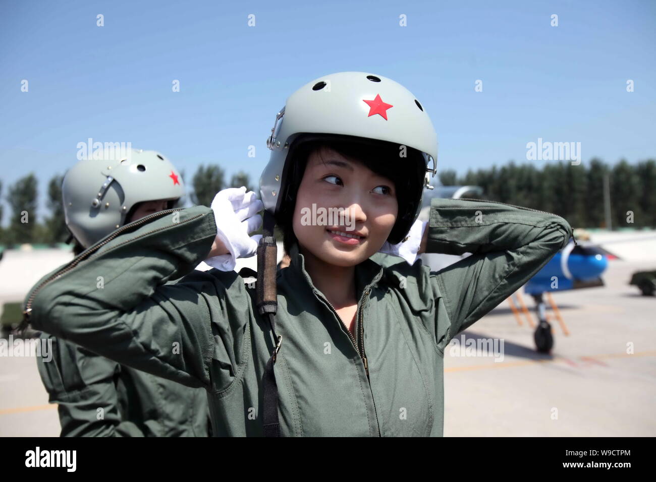 Young female fighter plane pilots of Chinese PLA Air Force wear the pilot helmets after a new flight suits delivery ceremony at an airport in Tangshan Stock Photo