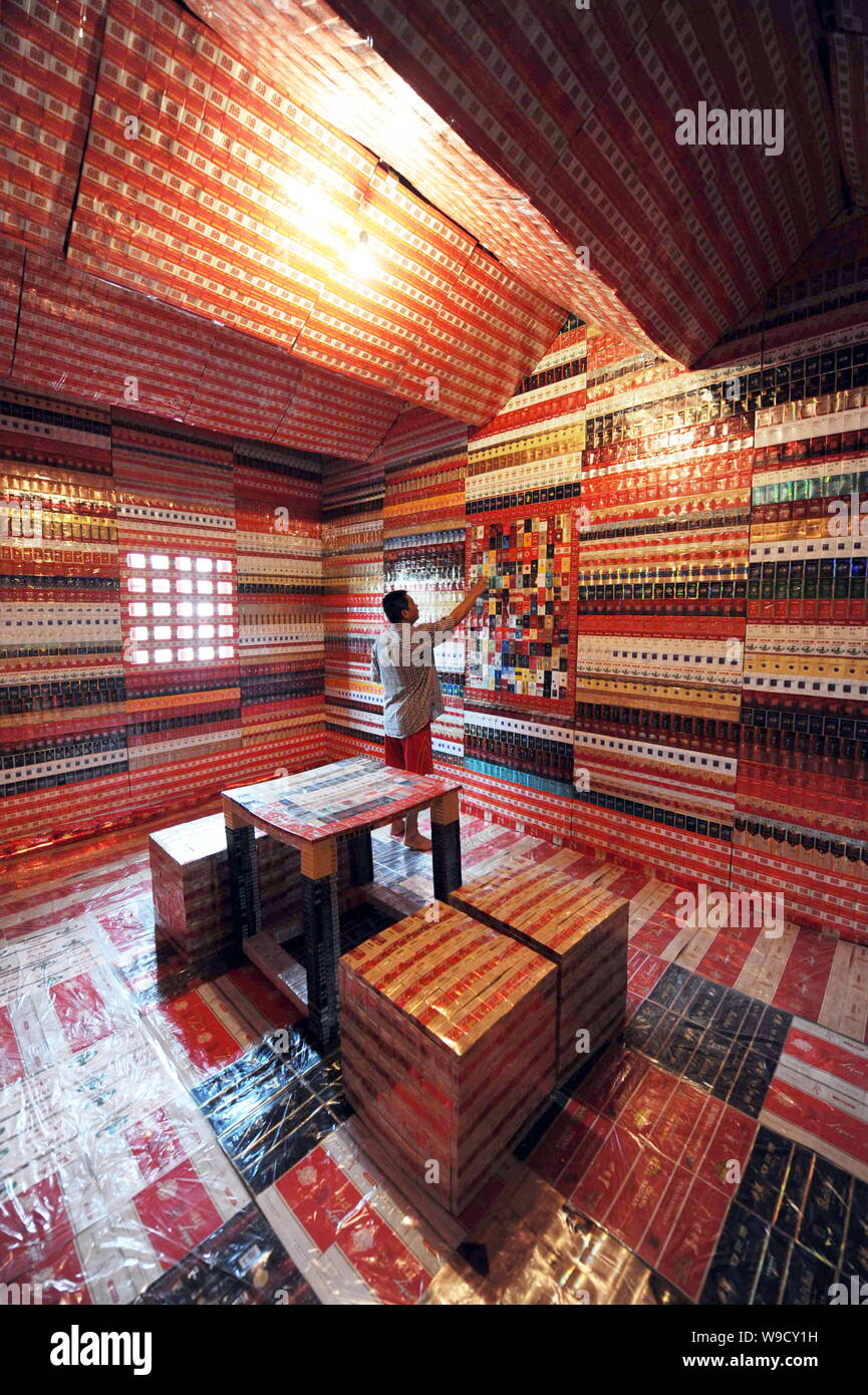 Chinese collector Wang Guohua looks at his collections of cigarette boxes  in a room in Hangzhou city, east Chinas Zhejiang province, Tuesday, 25  Augus Stock Photo