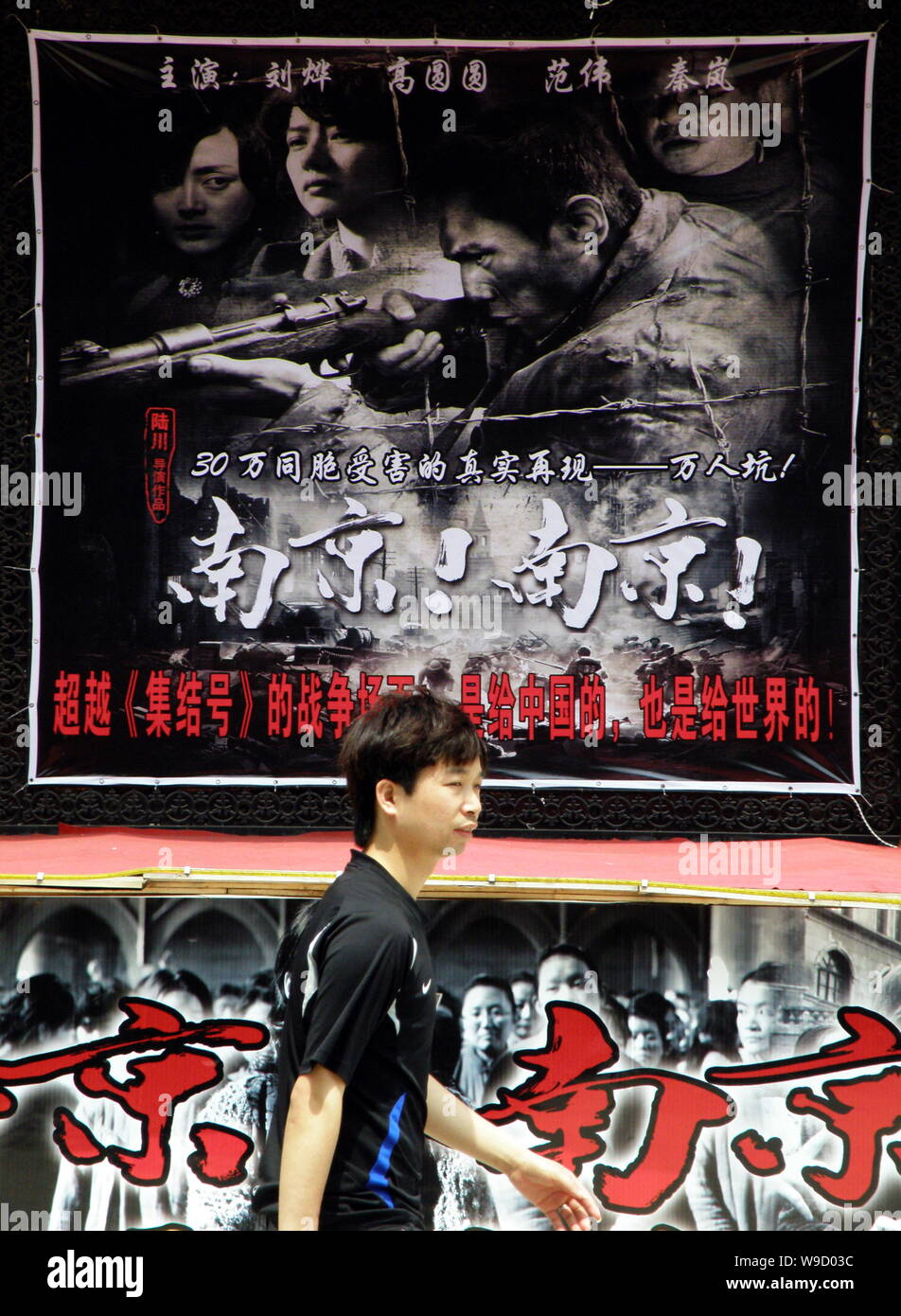 --FILE--A Chinese man walks past a poster for the movie City of Life and Death, directed by Chinese film director Lu Chuan, at a cinema in Yichang cit Stock Photo
