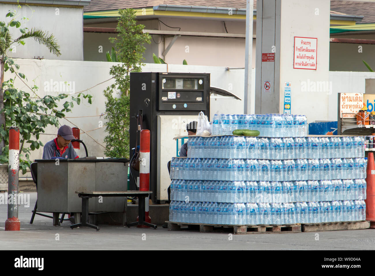 BANGKOK, THAILAND, APR 03 2019, Gas station pump with a many of drinking water in plastic bottles as a reward for the driver. Stock Photo