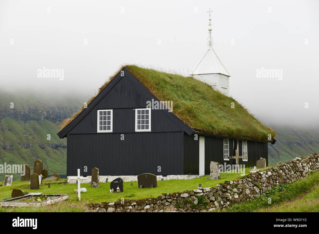 Traditional turf church in Faroe islands on foggy day. Kaldbak Stock Photo