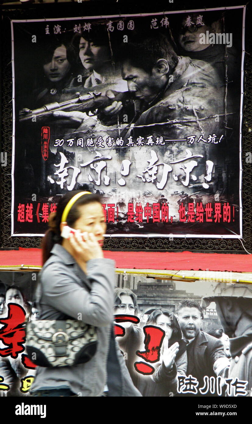 --FILE--A Chinese woman walks past a poster for the movie City of Life and Death, directed by Chinese film director Lu Chuan, at a cinema in Yichang c Stock Photo