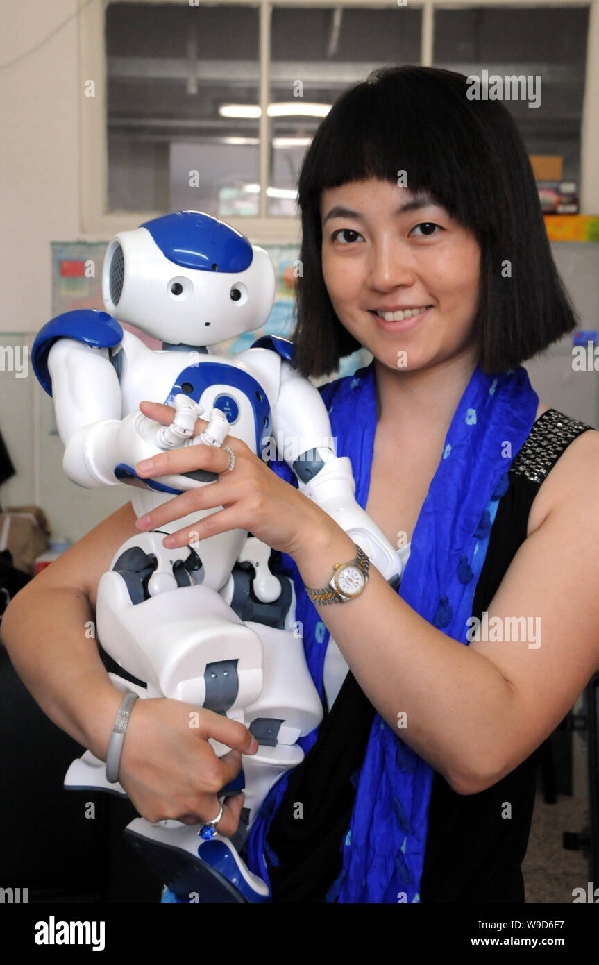 A woman is seen holding a Nao, the humanoide robot made by Aldebaran Robotics, at Harbin Institute of Technology in Harbin city, northeast Chinas Heil Stock Photo