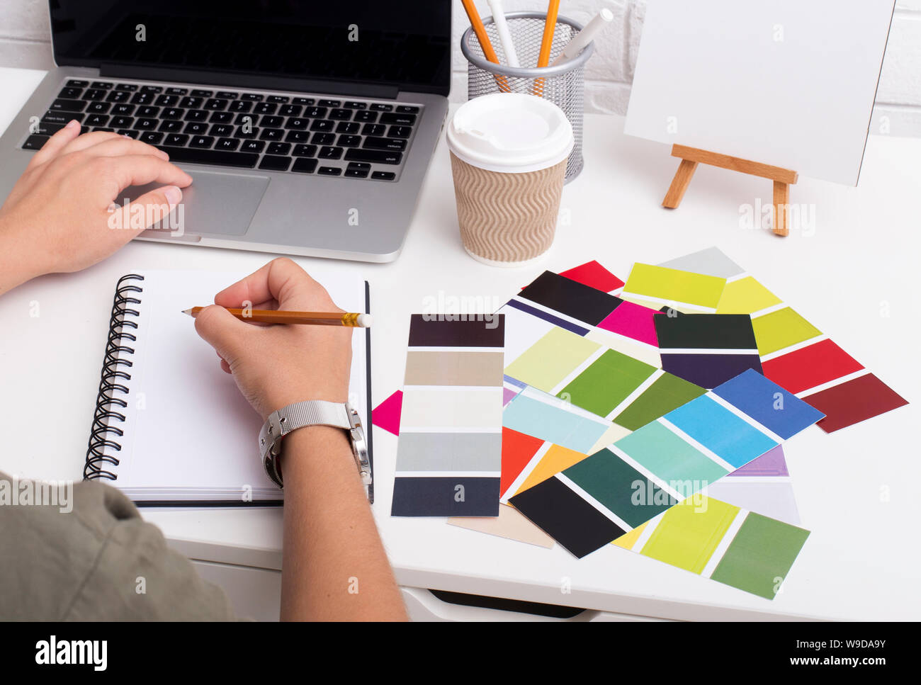 Woman writing in notebook and typing on laptop Stock Photo - Alamy