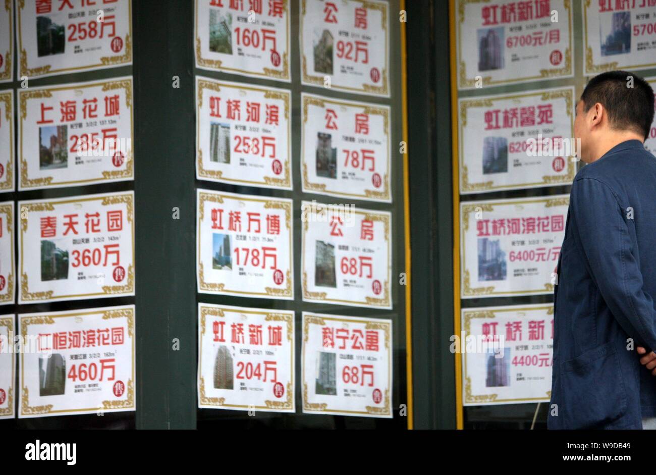 a man looks at advertisements of second hand houses outside advertisements for houses