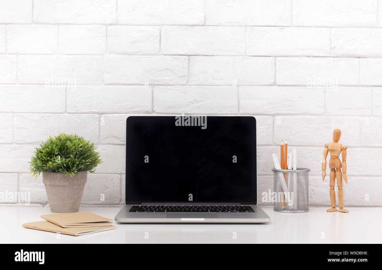 Laptop with black blank screen on modern white office table Stock Photo ...