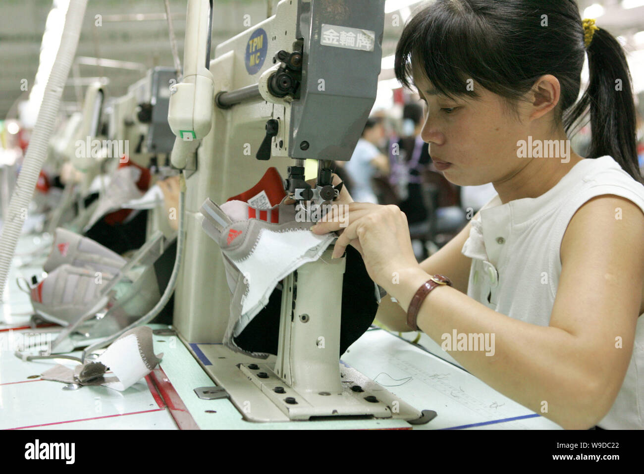 FILE-- Factory workers make Adidas shoes at the factory of Yue Yuen  Industrial (Holdings) Limited in Dongguan, Guangdong province September 20,  2005 Stock Photo - Alamy