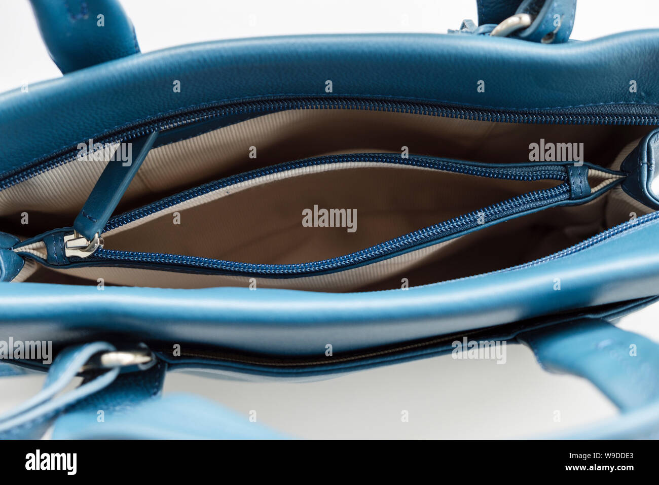 Top down view looking into an open zipped inner pocket compartment inside an empty handbag purse from above. Stock Photo