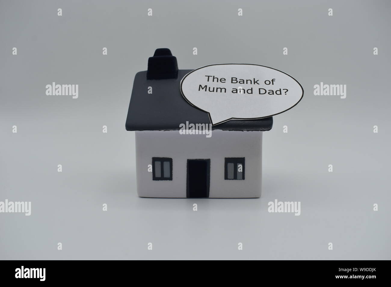 A model house with the words 'The Bank of Mum and Dad?' in a speech bubble on the roof. Stock Photo