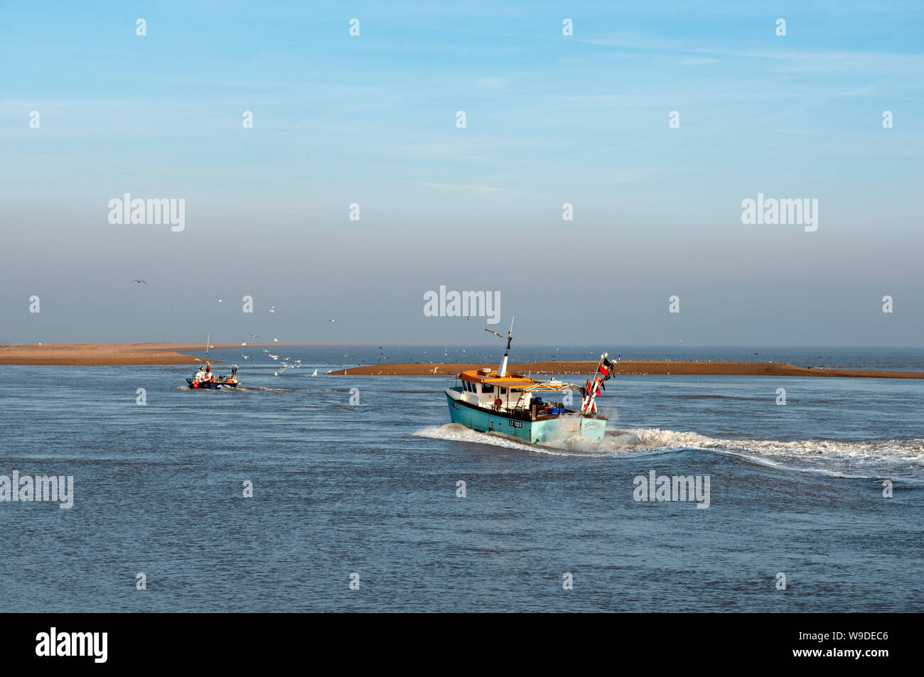 Fishing boats heading up towards Orford, river Ore estuary, Shingle Street, Suffolk, UK. Stock Photo