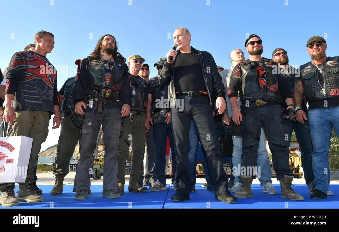 Russian President Vladimir Putin, center, stands with members of the Night Wolves biker club and their leader Alexander Zaldastanov, center left, as he addresses the Babylon Shadow bike show and camp August 10, 2019 near Sevastopol, Crimea, Russia. Stock Photo