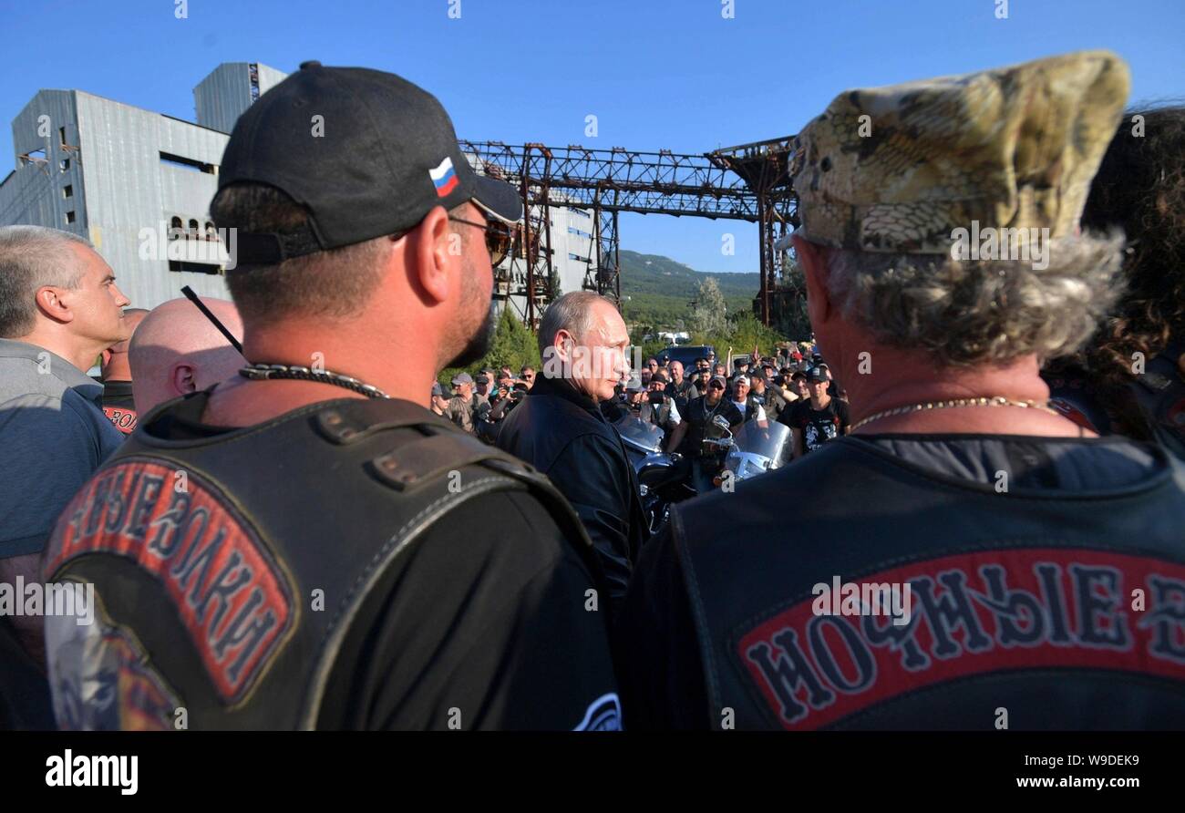 Russian President Vladimir Putin, center, stands with members of the Night Wolves biker club as he addresses the Babylon Shadow bike show and camp August 10, 2019 near Sevastopol, Crimea, Russia. Stock Photo