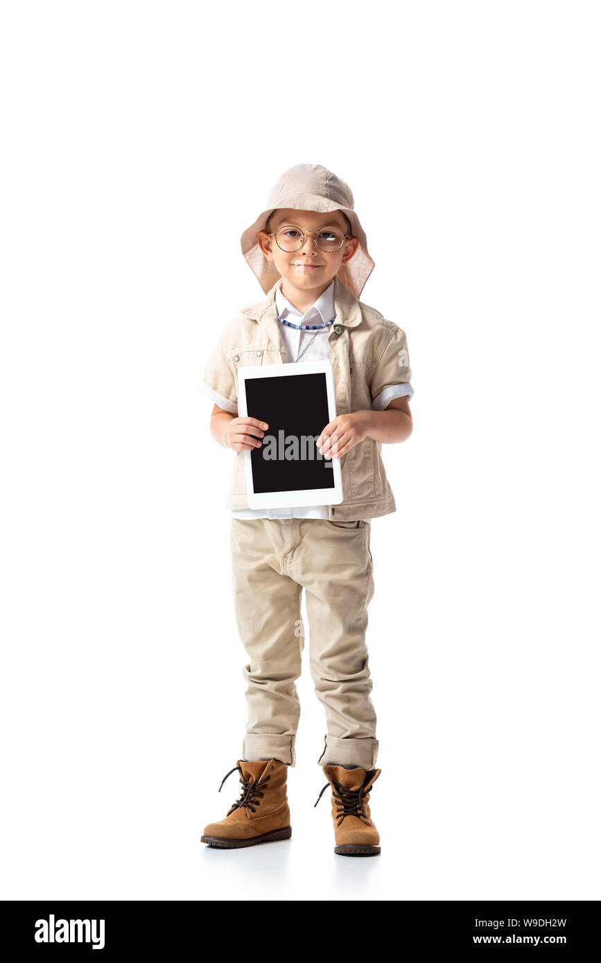 full length view of explorer child in glasses and hat holding digital tablet with blank screen on white Stock Photo