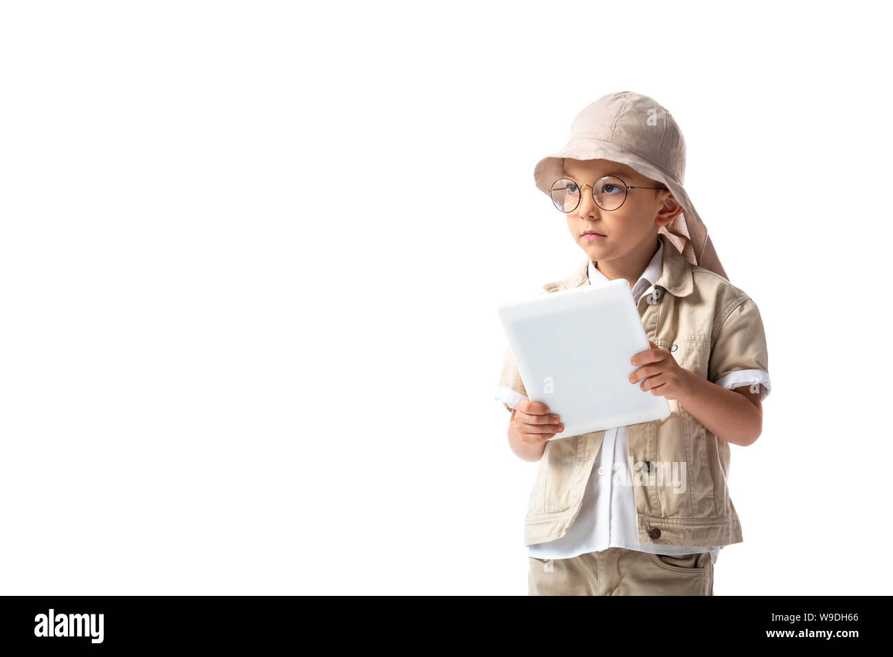 pensive explorer child in glasses and hat holding digital tablet and looking away isolated on white Stock Photo