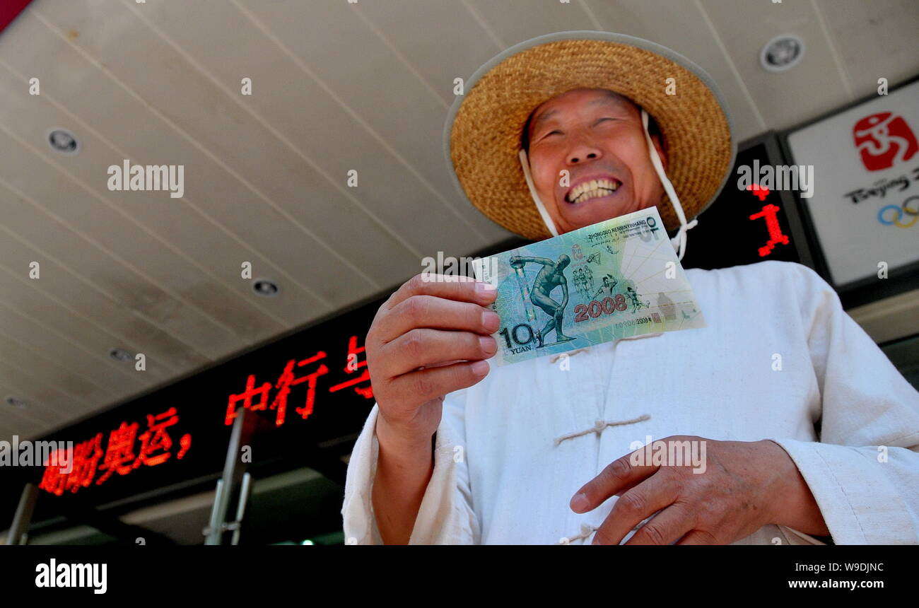 A Chinese man shows a ten yuan (1.46 USD) note issued to mark the Beijing  2008 Olympic Games outside a bank in Lanzhou city, northwest Chinas Gansu  pr Stock Photo - Alamy