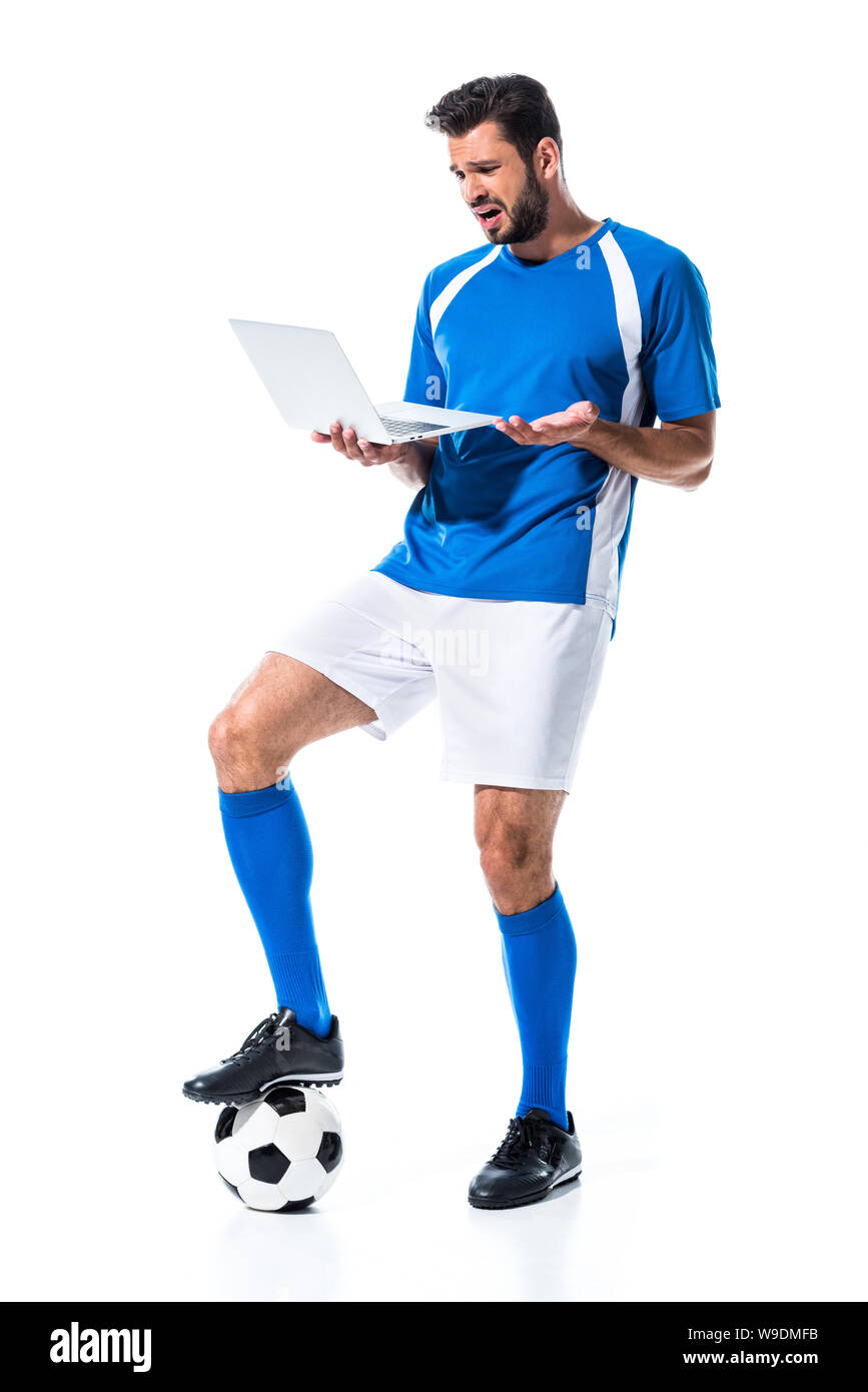 confused soccer player using laptop and standing on ball Isolated On White Stock Photo