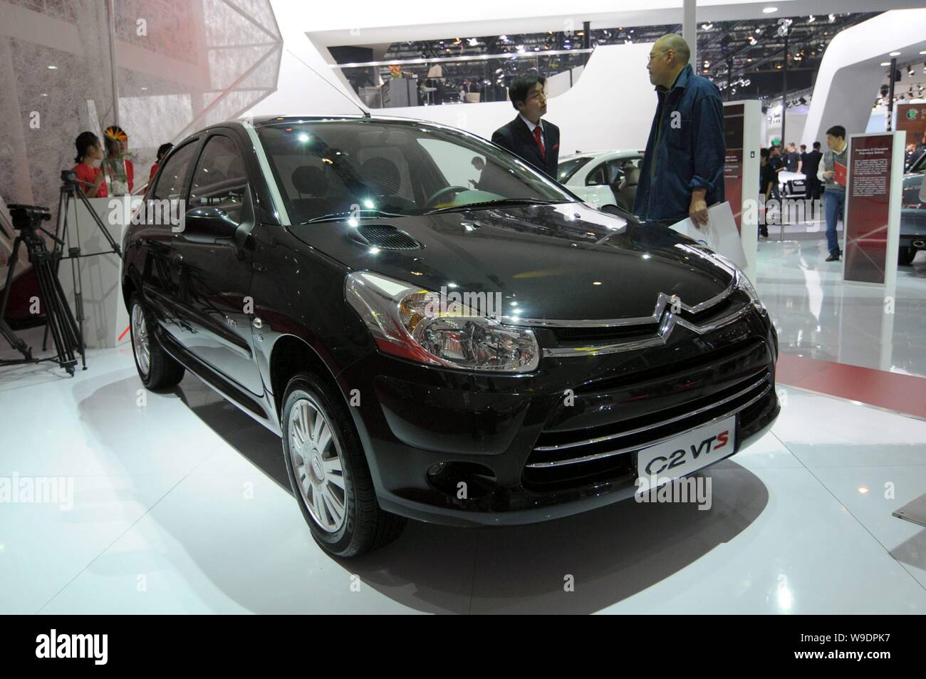 --FILE--Chinese visitors look at a Citroen C2 VTS at the Auto China 2008 car show in Beijing, China, 20 April 2008.   A senior official from PSA Peuge Stock Photo