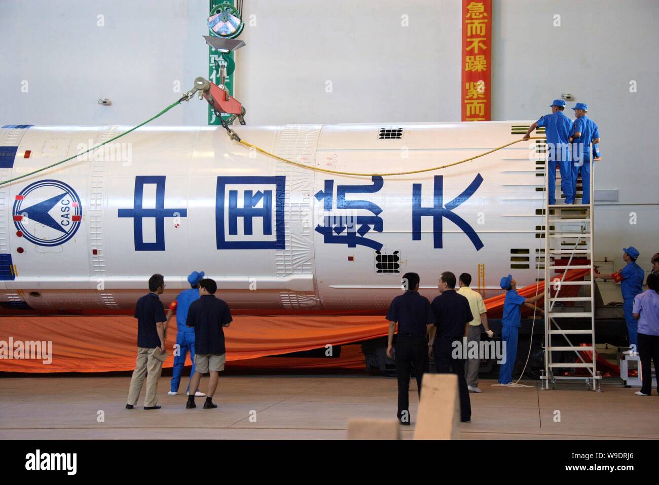 Chinese aeronautical scientists unload the second stage of a Long March 2F (CZ-2F) rocket during the preparation for the Shenzhou VII manned spaceflig Stock Photo